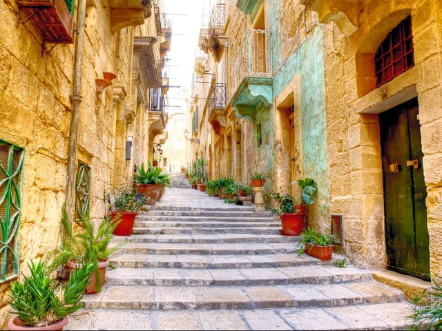 A picture of shallow steps surrounded on all sides by old buildings