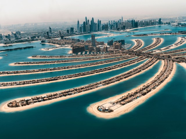 An aerial view of long strands of manmade island reaching outwards in the ocean