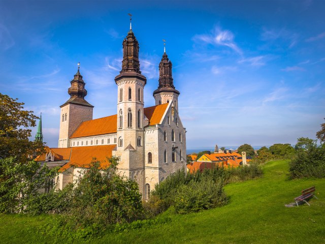 A picture of an old church with three steeples and an orange roof