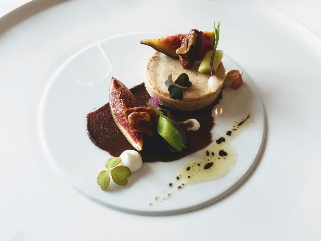 Artfully plated food on white dish and white tablecloth