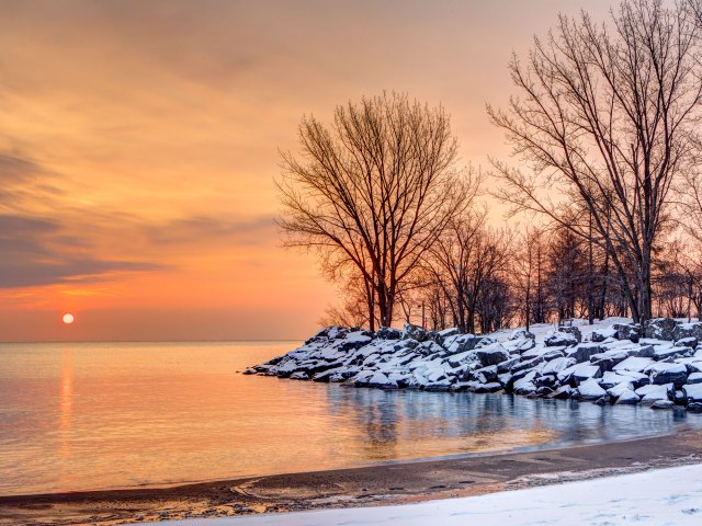 Snow-covered shore along Great Lakes at sunset