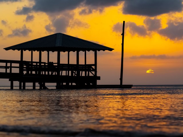 Covered dock over Alabama lake at sunset