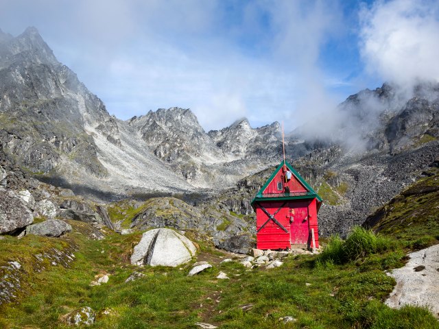 Red cabin in mountains of Talkeetna, Alaska