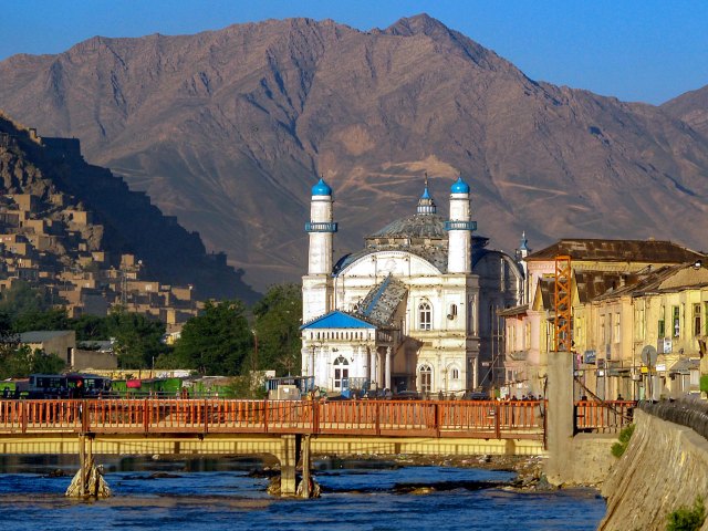 Mountains looming over buildings and river in Afghanistan