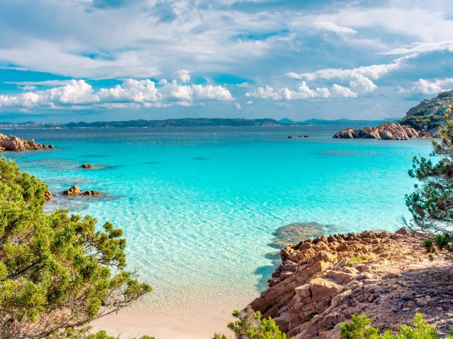 Pink sand beach along rocky cove on the Italian island of Budelli