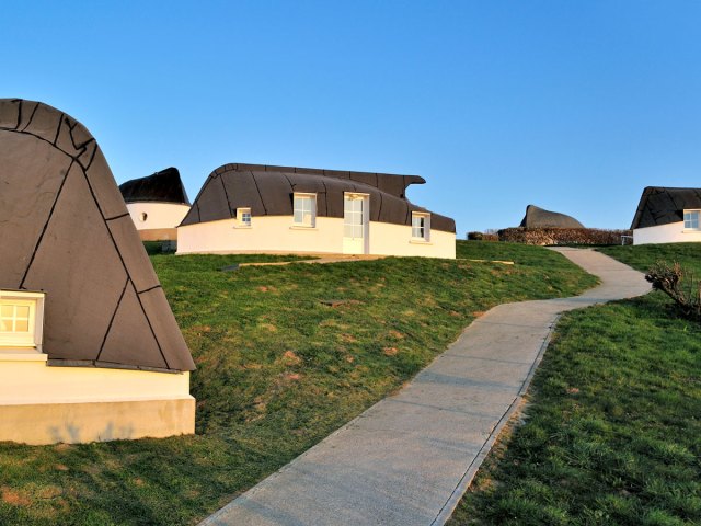 Pathway along series of upside-down boat houses in Équihen-Plage, France