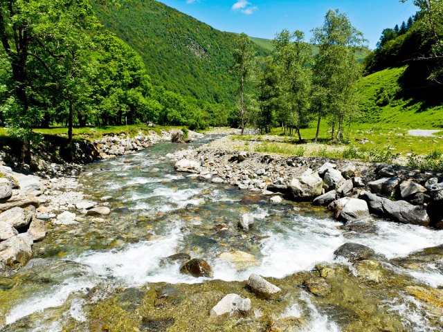 River running through lush landscape near Oô, France