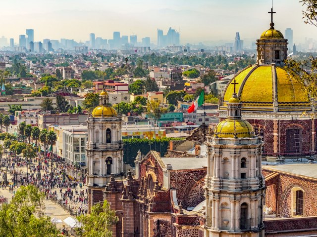 Aerial view of gold-domed Basilica of Our Lady of Guadalupe and Mexico City skyline