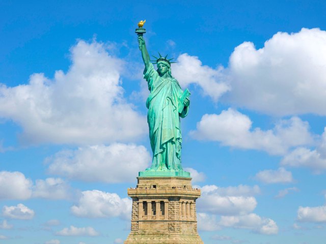 Statue of Liberty in front of partly cloudy skies in New York City