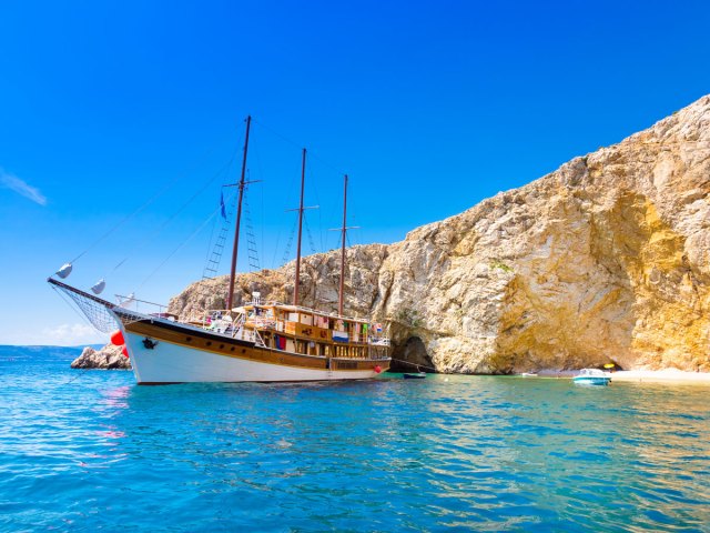 Tall ship moored off the coast of rocky Croatian island