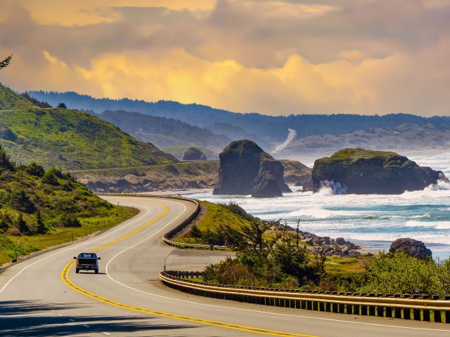 Car driving along coastal cliffs on California's Pacific Coast Highway