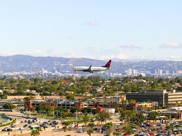 Aerial view of airplane on low approach over buildings