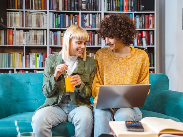 Couple sitting on couch looking at laptop