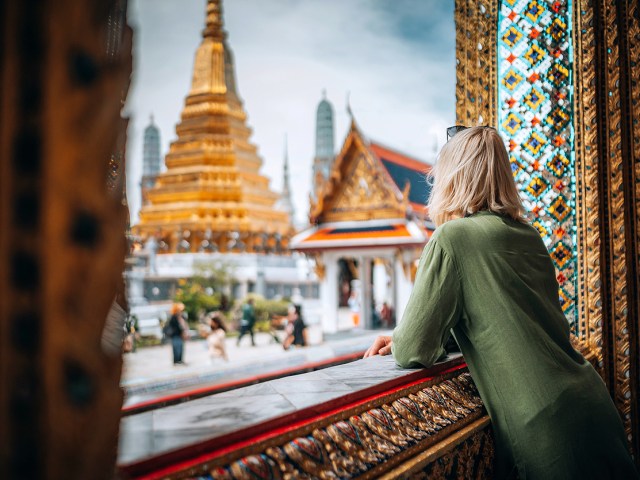 Traveler gazing out window at golden temple