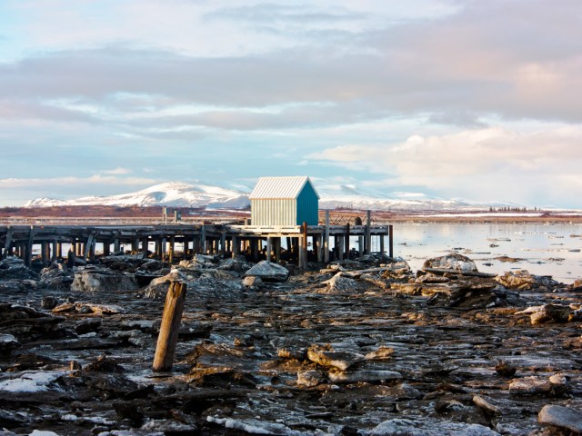 Small structure on wooden pier extending into lake in Alaska