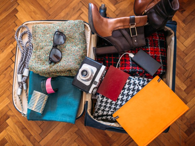 Overhead view of packed suitcase on floor