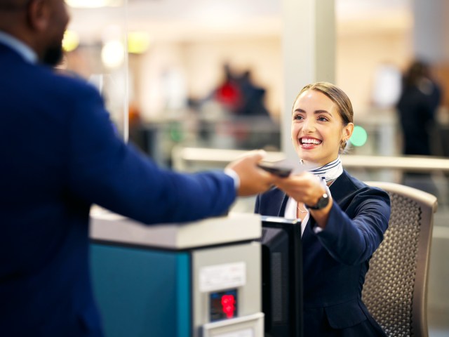 Passenger handing documents to ticket agent at airport