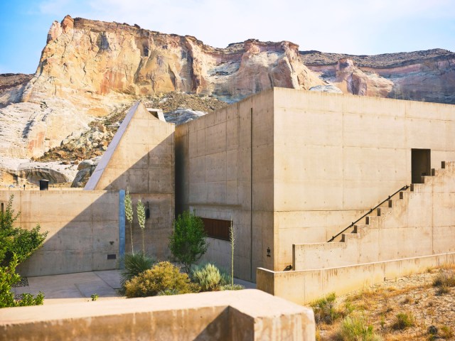 Stone walls of the Amangiri resort in Utah with mountains in background