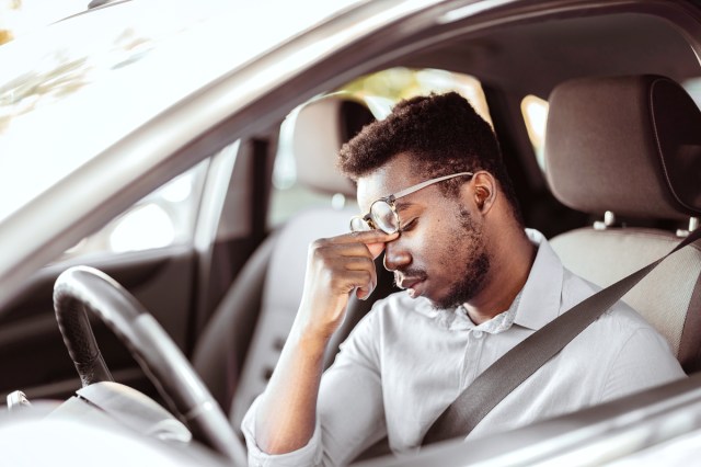 Driver rubbing eyes in car