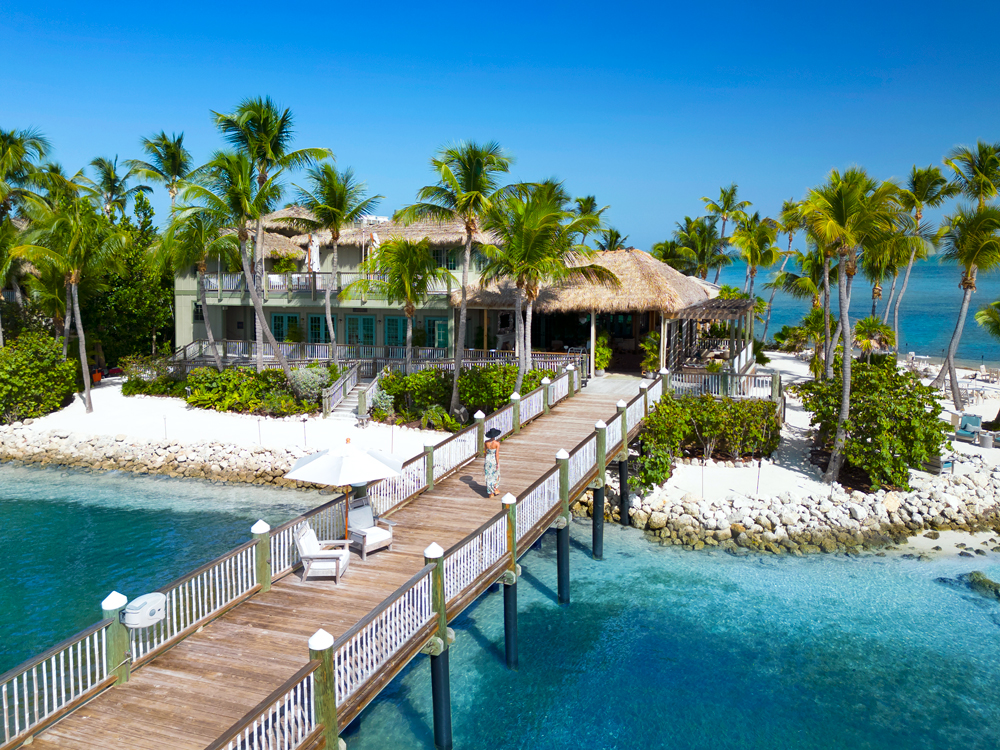 Aerial view of guest walking on pier to  Little Palm Island Resort in Florida