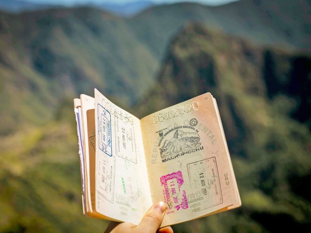 Person holding passport and showing visa stamps