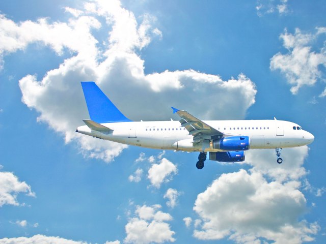 Airbus A319 airplane against partly cloudy sky