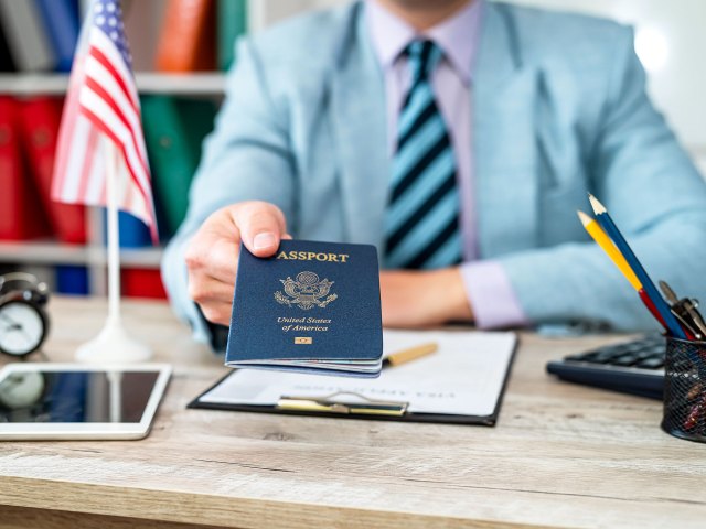 Person at desk handing over passport