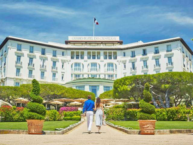 Couple walking through garden toward Grand-Hôtel du Cap-Ferrat in Côte d’Azur, France