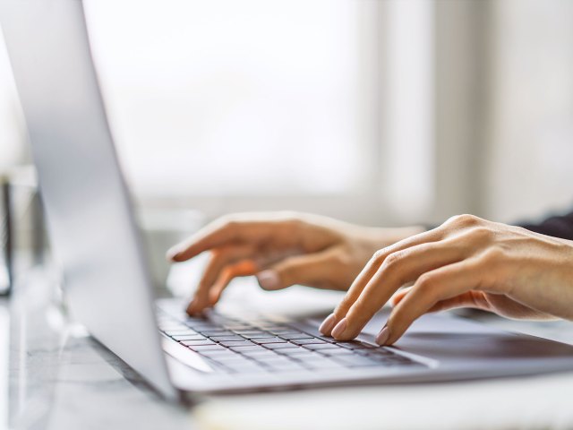 Close up of hands typing on computer