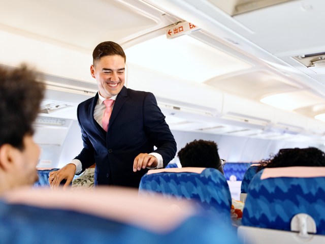 Flight attendant checking on passengers