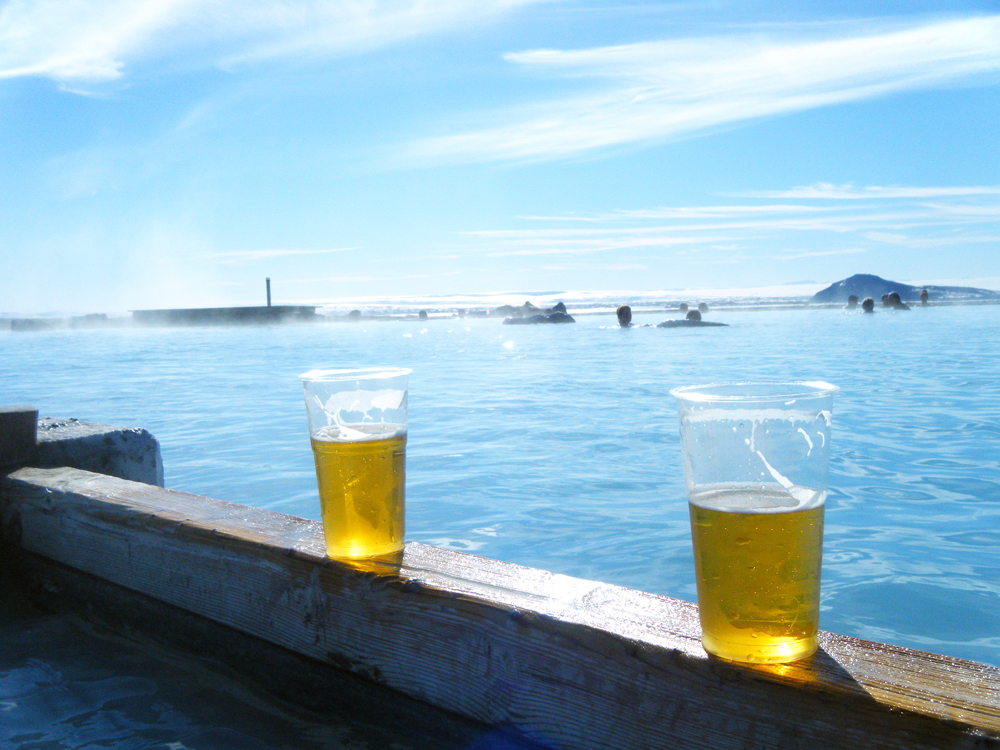 Cups of beer sitting on ledge overlooking hot springs in Iceland