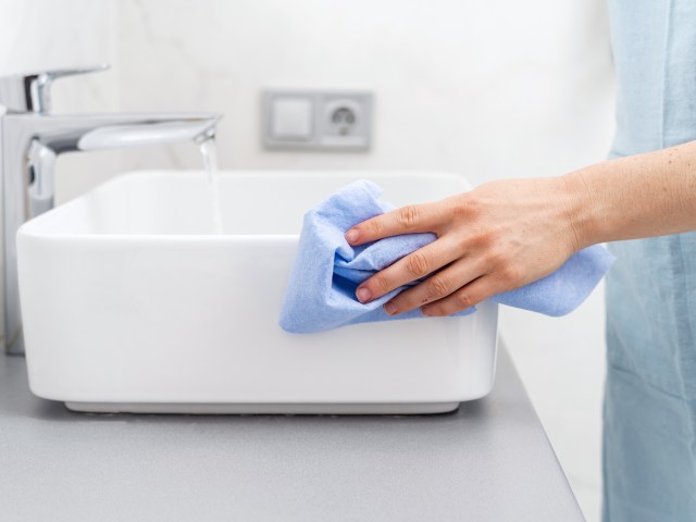 Person wiping down sink