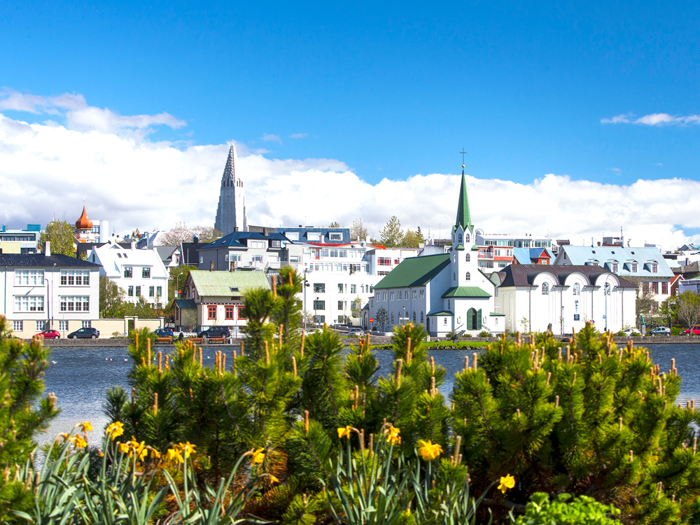 View of Frakirkjan church and other buildings across body of water in Reykjavik, Iceland