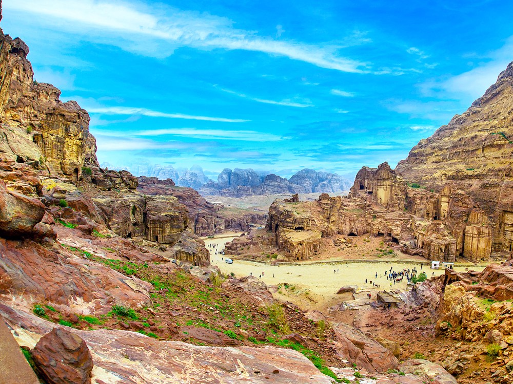 Overview of tourists admiring architecture of Petra, Jordan, from viewpoint