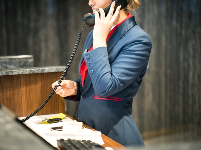 Hotel front desk agent using telephone