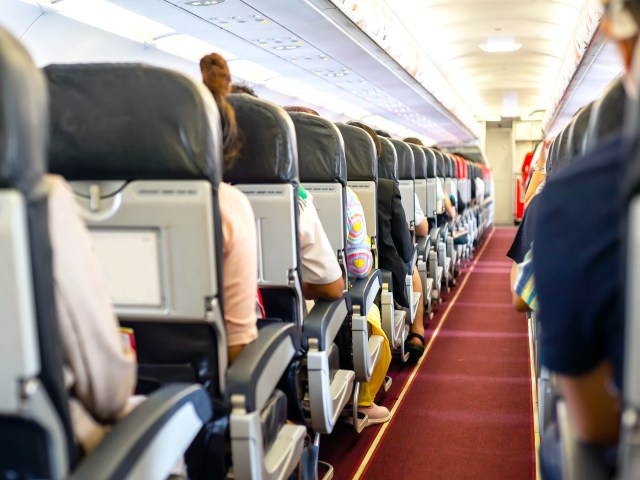 View of airplane cabin looking from back to front