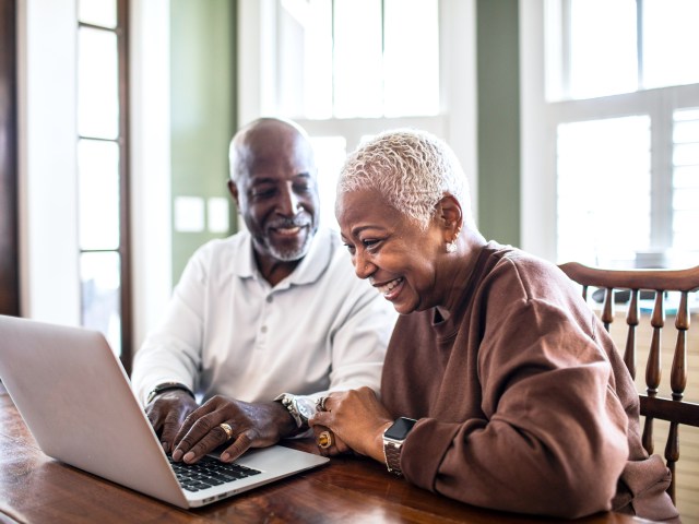 Couple using laptop at table