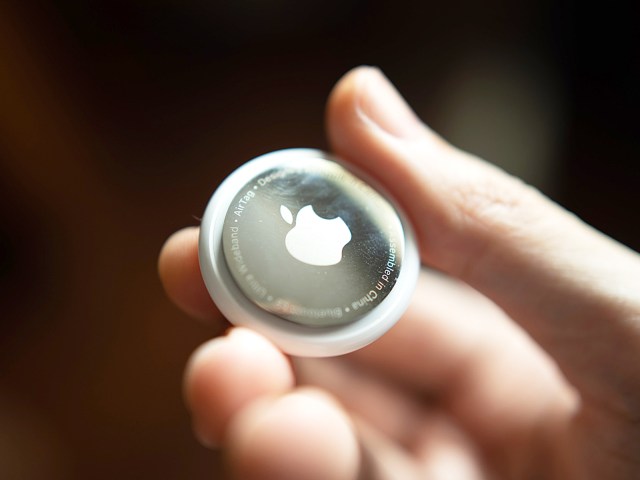 Close-up image of person holding Apple AirTag device