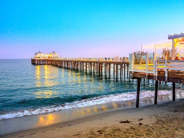 Malibu Pier extending into Pacific Ocean, illuminated at dusk