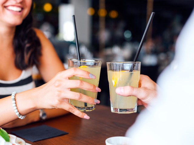 Two people toasting drinks