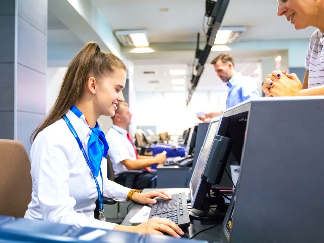 Airline passenger talking to ticket agent at check-in desk