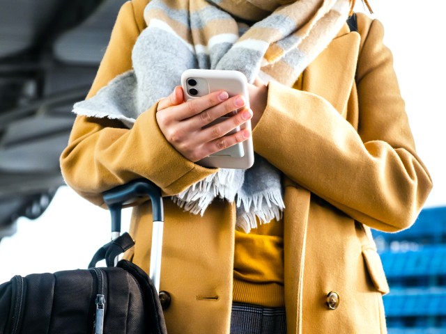 Traveler at airport wearing coat and scarf 