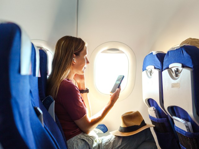 Airplane passenger looking at cellphone