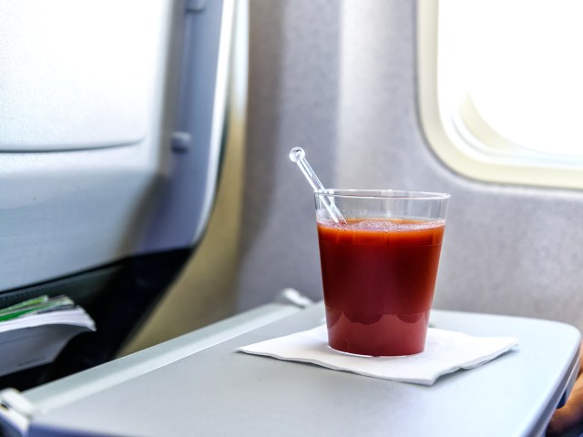 Cup of tomato juice on airplane tray table