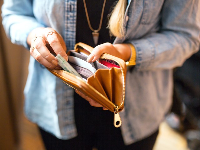 Close-up image of person taking cash out of wallet