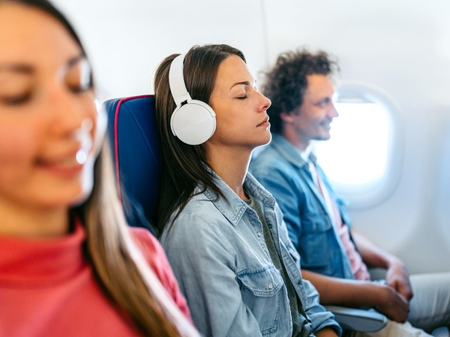 Airplane passenger wearing noise-canceling headphones