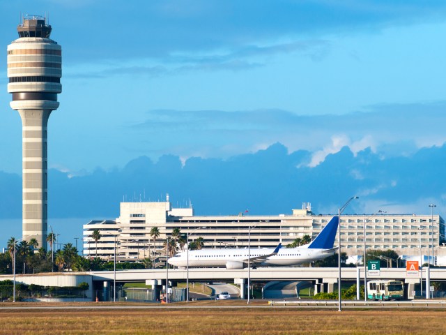 Control tower and jet taxiing at Orlando International Airport in Florida