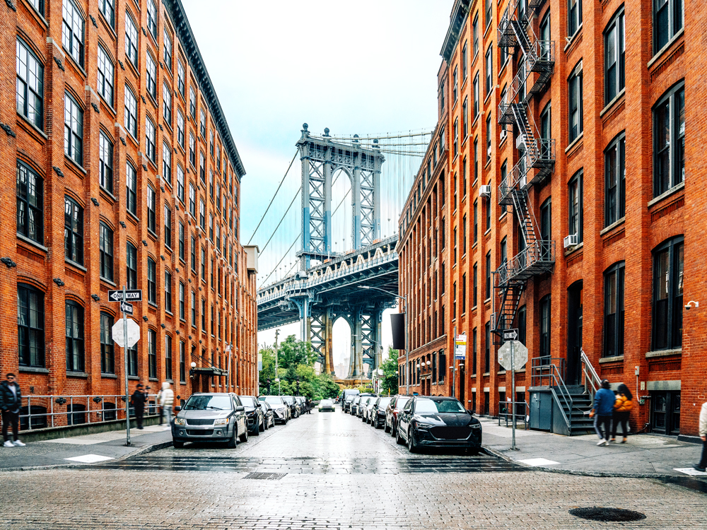 View of Manhattan Bridge between buildings in Brooklyn, New York