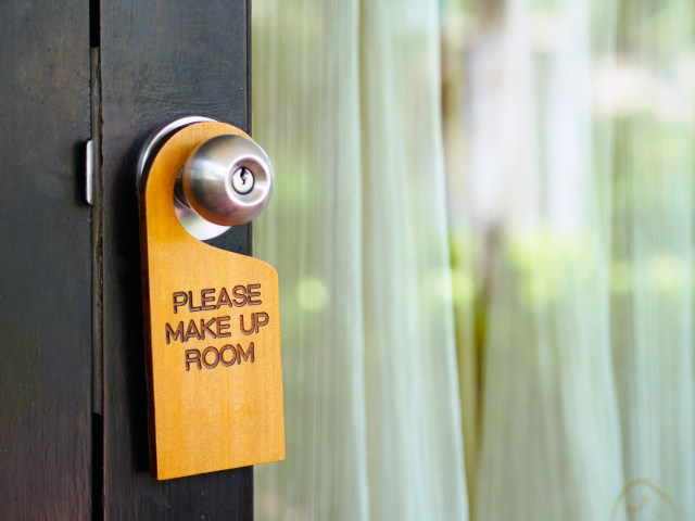 Close-up view of sign on hotel room door stating "Please make up room"