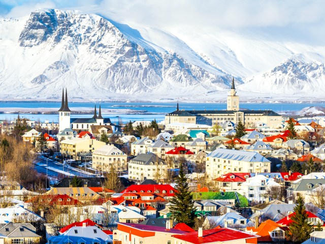 Cityscape of Reykjavík, Iceland, with bay and snowy mountains in background, seen from above